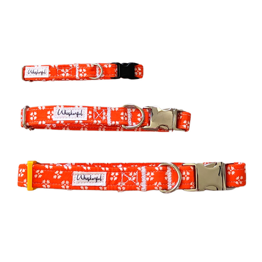 Image showcasing our Bright Orange with White Floral Collars in three sizes: Small, Medium, and Large. The collars are adjustable, made from 100% cotton, and feature soft interfacing for Small and medium interfacing for Medium sizes. Small collar has a breakaway buckle and a regular buckle, while Medium has an elegant aluminum buckle. The Large collar has a lightweight and durable nylon webbing, along with an elegant aluminum buckle. The image may vary from the actual product in terms of pattern placement.