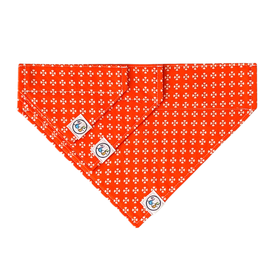 Image of three bandanas in different sizes (small, medium, and large) showcasing the bright orange with white floral design for size comparison.